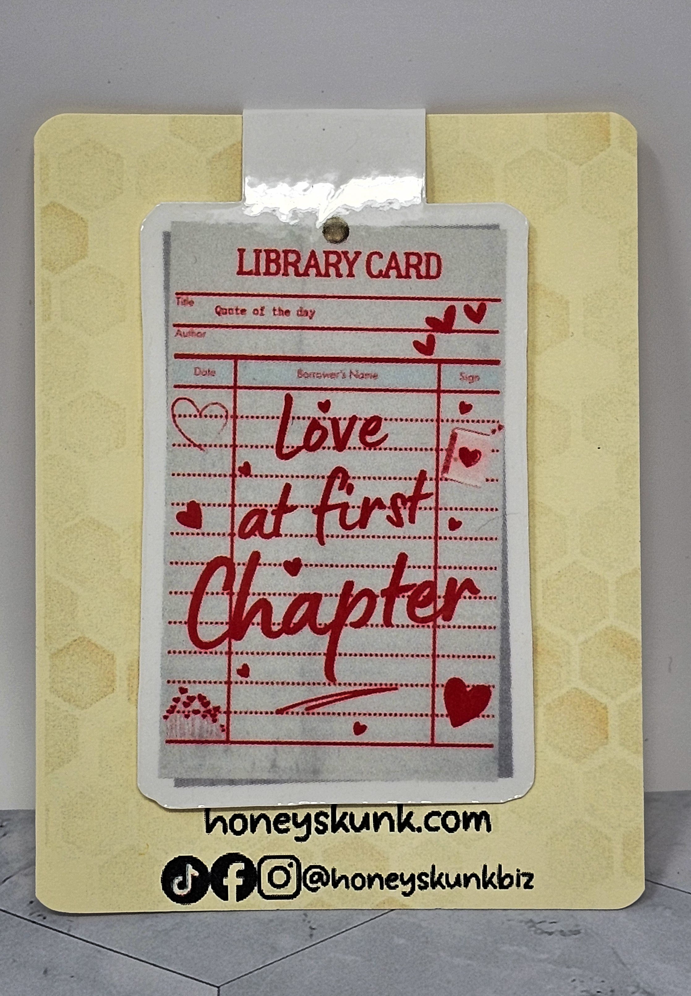 Library card with 'Love at first chapter' text on a honeycomb-patterned card, featuring the brand 'honeyskunk.com'.
