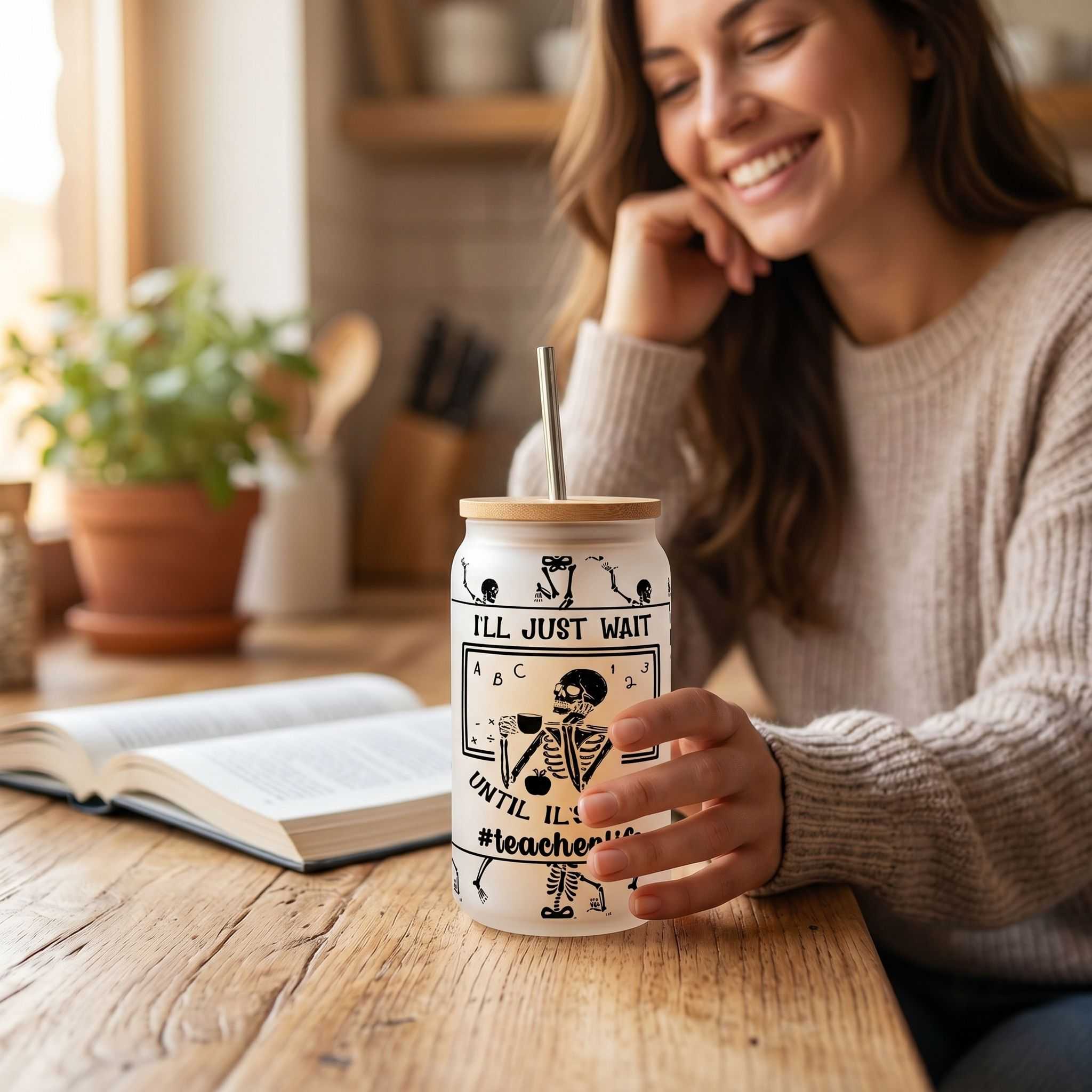 Close-up of a 16 oz clear glass Libby style tumbler with sublimated design on a wooden countertop, lit by warm natural sunlight.