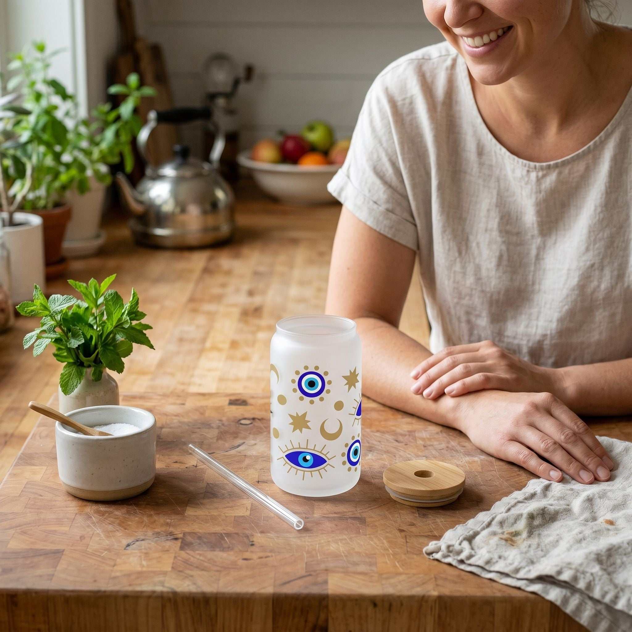 Overhead view of a tiny Libby glass cup on a kitchen countertop with straw and bamboo lid, emphasizing detailed pattern and casual setting.