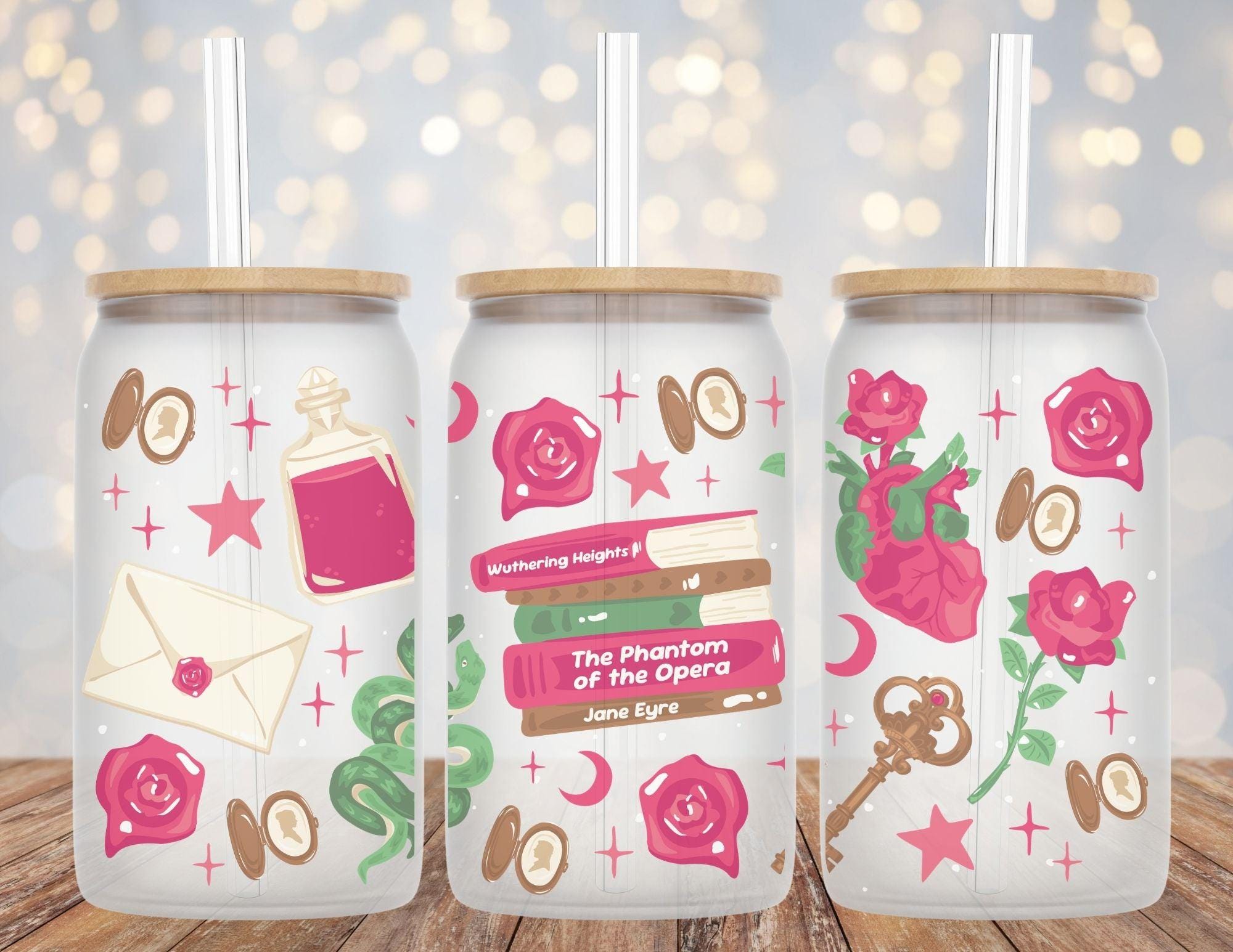 Three glass tumblers with decorative designs on a wooden surface with a blurred light background.